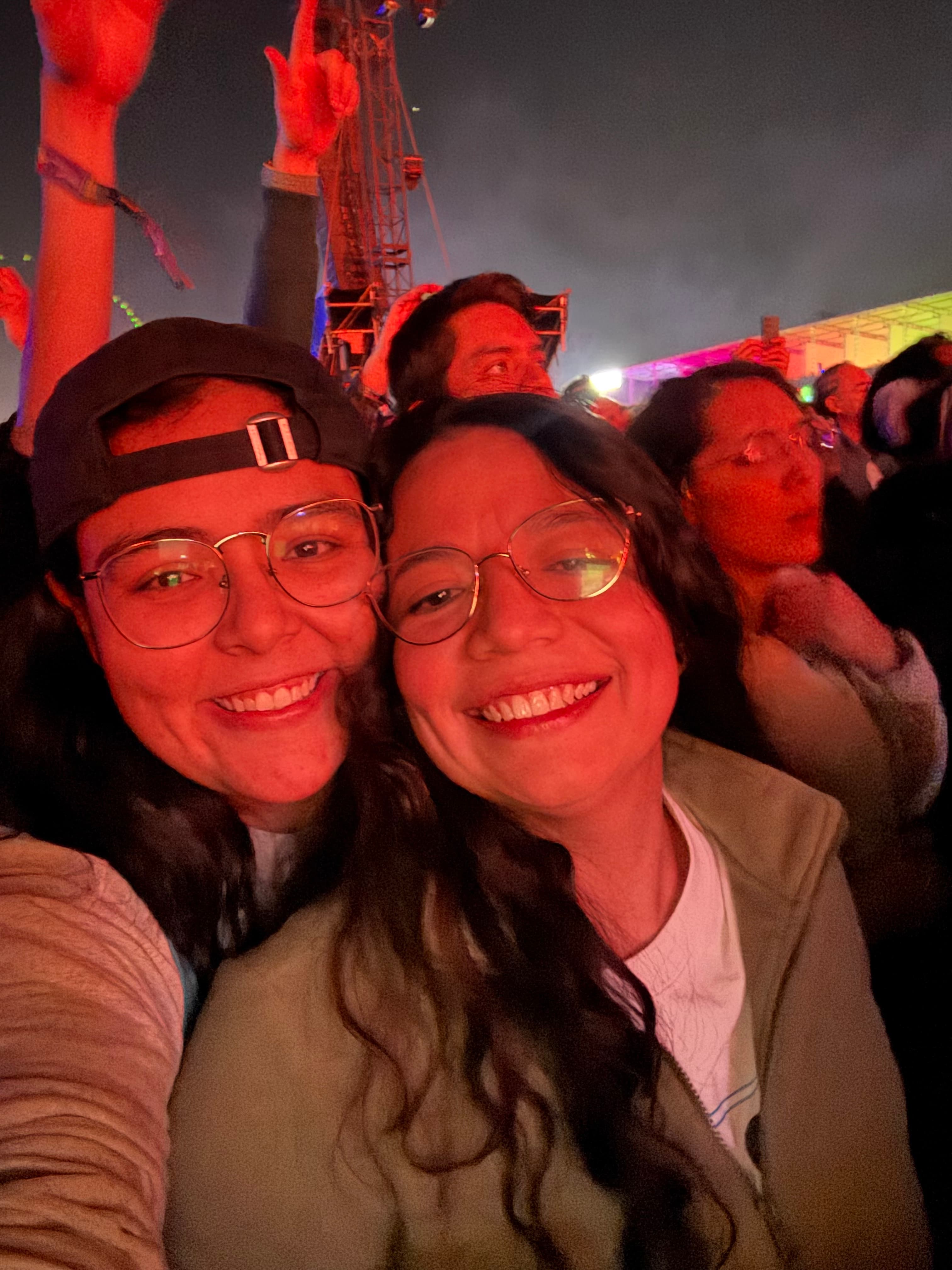 Mariel y Ale sonriendo al aire libre durante un concierto.